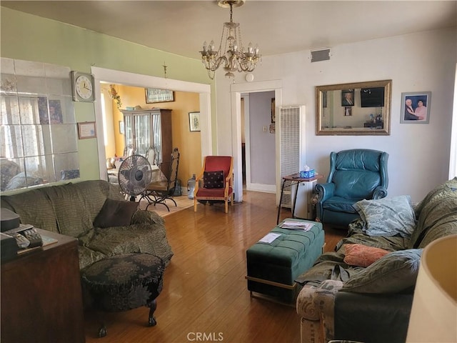 living room with wood-type flooring and a notable chandelier