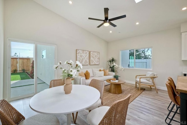 interior space featuring ceiling fan, high vaulted ceiling, and light wood-type flooring