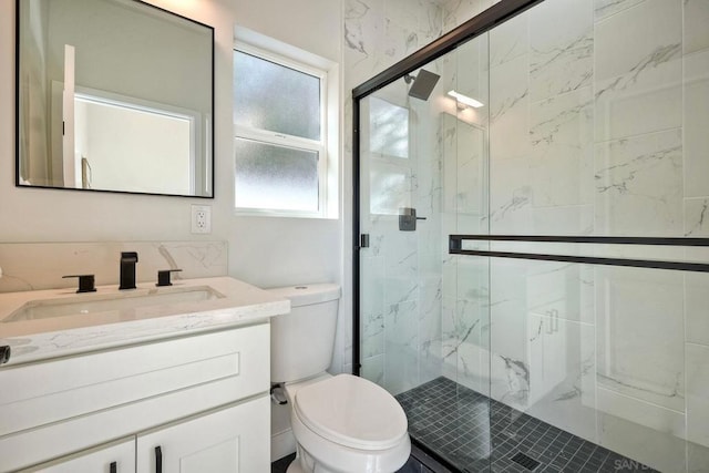 bathroom featuring toilet, walk in shower, and vanity