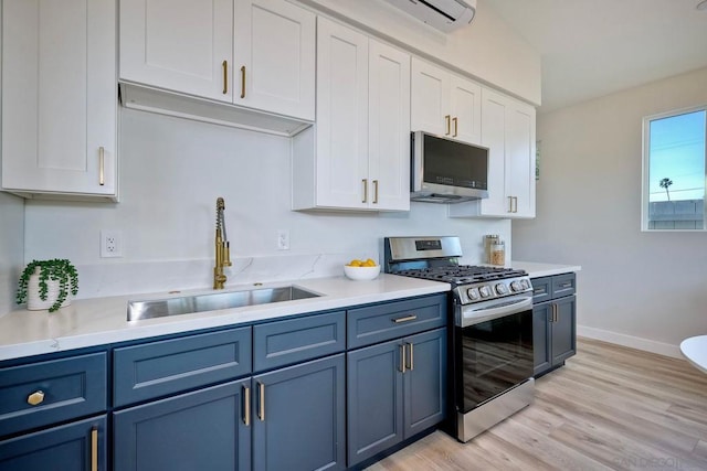 kitchen with white cabinets, appliances with stainless steel finishes, sink, and blue cabinetry