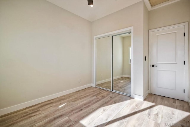 unfurnished bedroom with a closet and light wood-type flooring