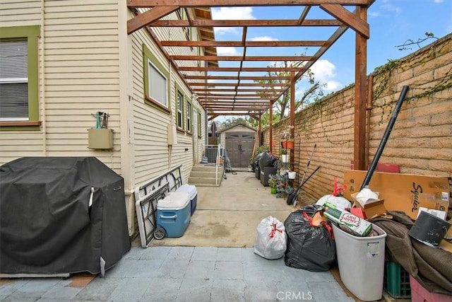 view of patio featuring area for grilling, a storage shed, and a pergola