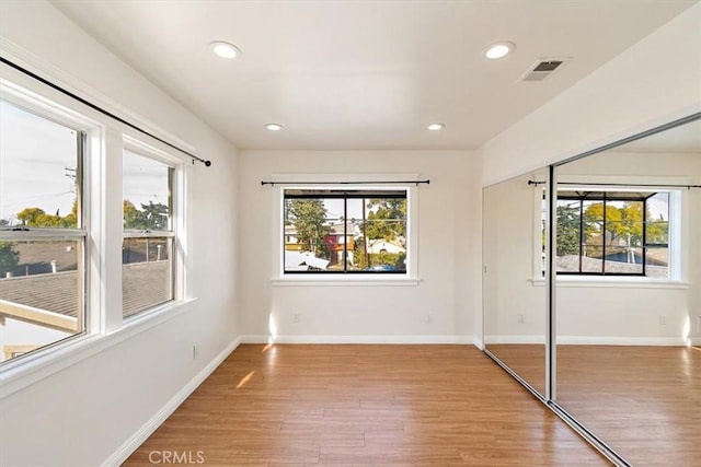 unfurnished bedroom featuring wood-type flooring and multiple windows