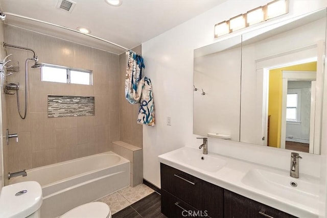 full bathroom featuring tile patterned flooring, plenty of natural light, shower / bathtub combination with curtain, and toilet