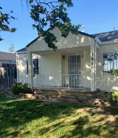 rear view of property featuring a lawn