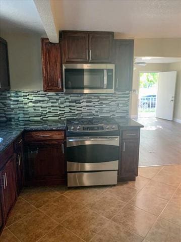 kitchen with light tile patterned floors, stainless steel appliances, decorative backsplash, dark brown cabinetry, and beamed ceiling