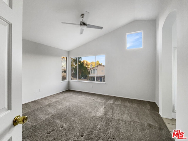 empty room with carpet floors, plenty of natural light, lofted ceiling, and ceiling fan