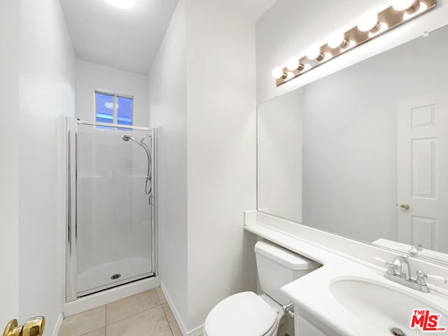 bathroom featuring toilet, tile patterned floors, a shower with door, and vanity