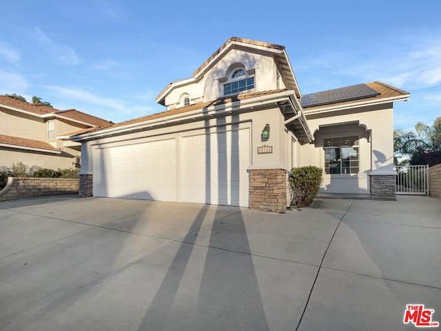 view of front of house featuring a garage and solar panels