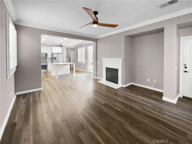 unfurnished living room with ceiling fan, dark hardwood / wood-style flooring, and crown molding