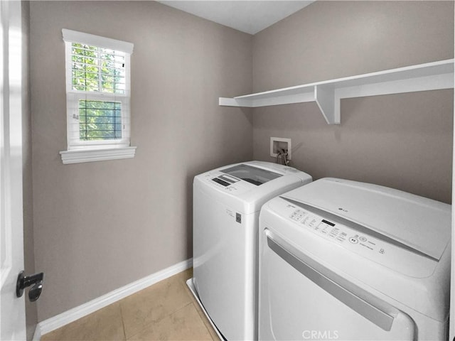 clothes washing area with light tile patterned floors and washer and clothes dryer