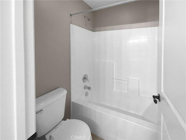 bathroom with shower / bathing tub combination and toilet