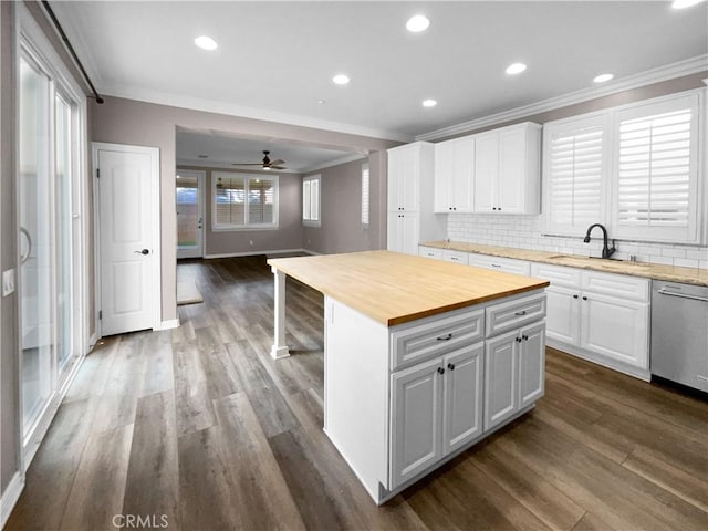 kitchen with a center island, wooden counters, white cabinetry, ceiling fan, and stainless steel dishwasher