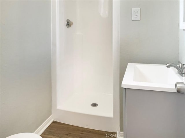 bathroom featuring walk in shower, vanity, and hardwood / wood-style flooring