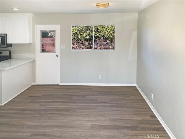 unfurnished dining area with dark hardwood / wood-style floors