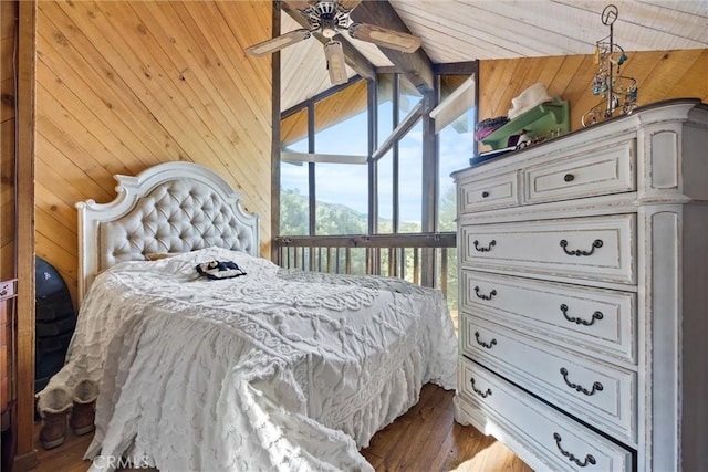 bedroom featuring ceiling fan, hardwood / wood-style floors, wooden walls, and lofted ceiling with beams