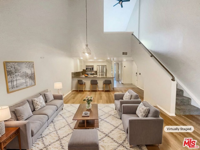 living room featuring a high ceiling and light hardwood / wood-style floors