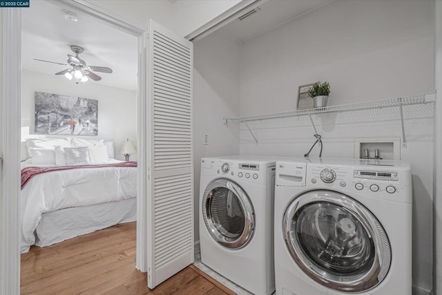 clothes washing area featuring washer and clothes dryer, ceiling fan, and hardwood / wood-style floors