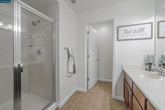 bathroom featuring tile patterned flooring, vanity, and a shower with shower door