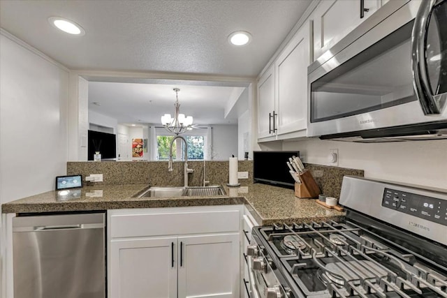 kitchen featuring an inviting chandelier, white cabinetry, stainless steel appliances, decorative light fixtures, and sink