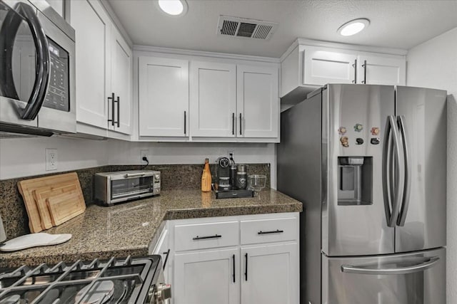 kitchen featuring white cabinets, appliances with stainless steel finishes, and a textured ceiling