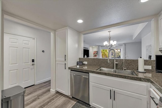 kitchen featuring sink, white cabinets, dishwasher, and a notable chandelier