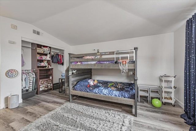 bedroom featuring hardwood / wood-style flooring and lofted ceiling