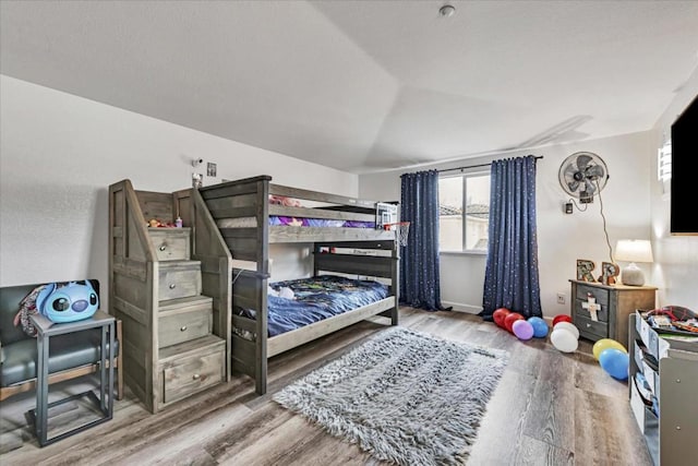 bedroom with vaulted ceiling and hardwood / wood-style floors