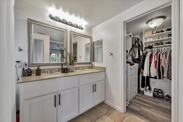 bathroom featuring a textured ceiling, tile patterned floors, and vanity