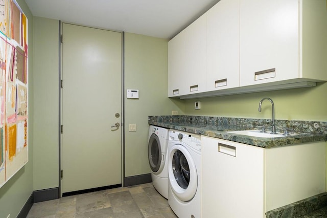 laundry room with washing machine and dryer, cabinets, and sink