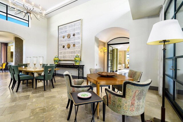 dining area featuring french doors, a high ceiling, and a chandelier