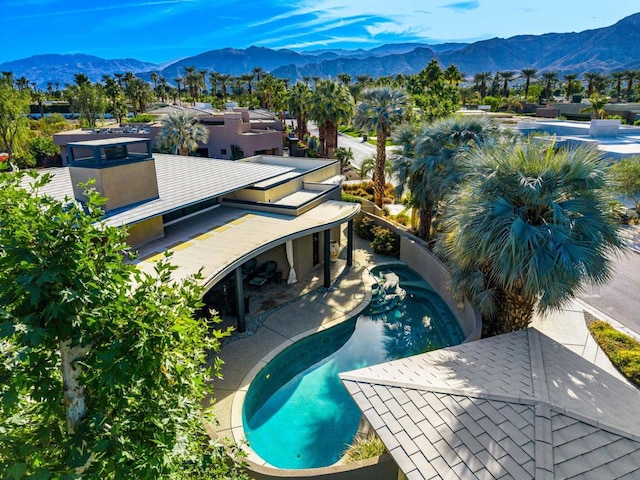 view of swimming pool with a mountain view and a patio