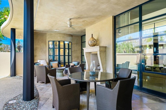 view of patio with ceiling fan and an outdoor fireplace