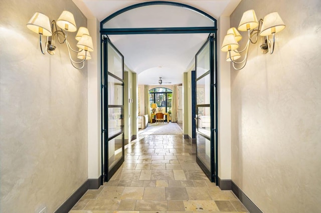 hall featuring expansive windows and a notable chandelier