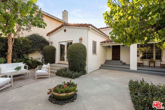 rear view of house featuring french doors, an outdoor living space, and a patio area