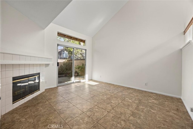 unfurnished living room with tile patterned floors, a fireplace, and high vaulted ceiling