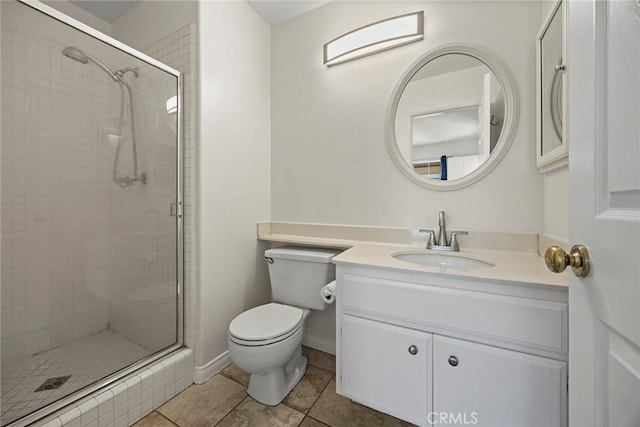 bathroom featuring vanity, toilet, tile patterned flooring, and a shower with door