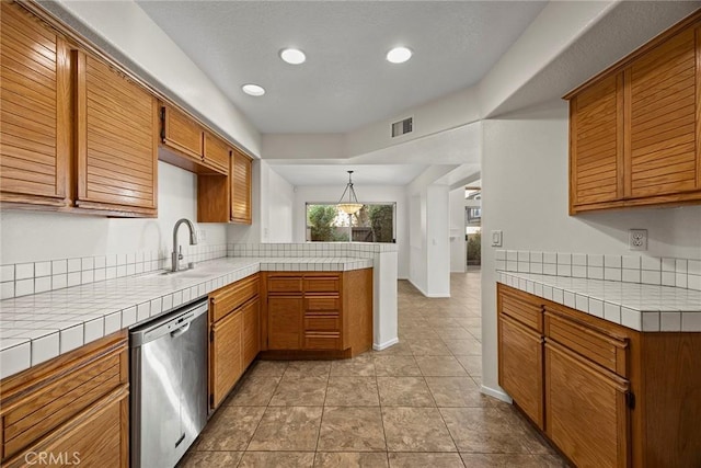 kitchen featuring kitchen peninsula, tile counters, dishwasher, hanging light fixtures, and sink