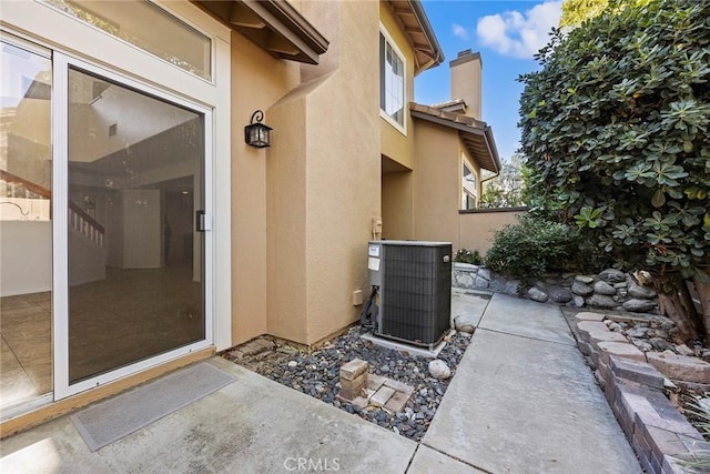 property entrance with a patio area and central AC unit