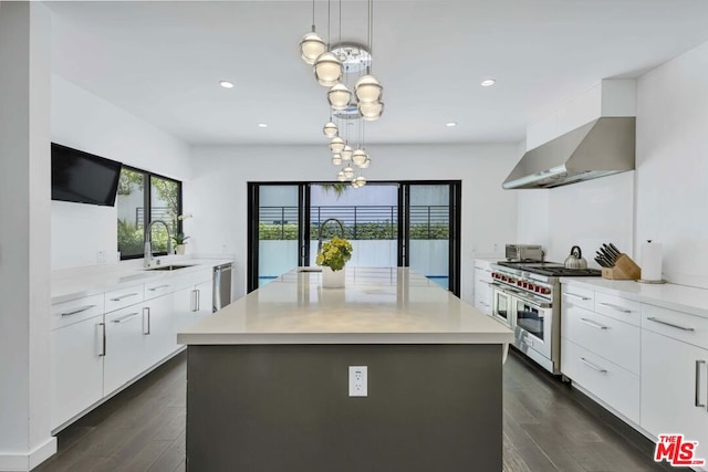 kitchen with sink, white cabinetry, a center island, appliances with stainless steel finishes, and pendant lighting