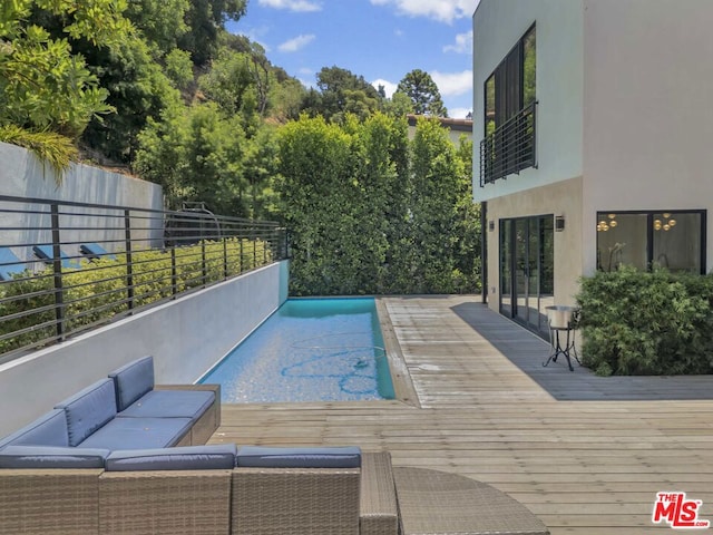 view of pool with a wooden deck and outdoor lounge area