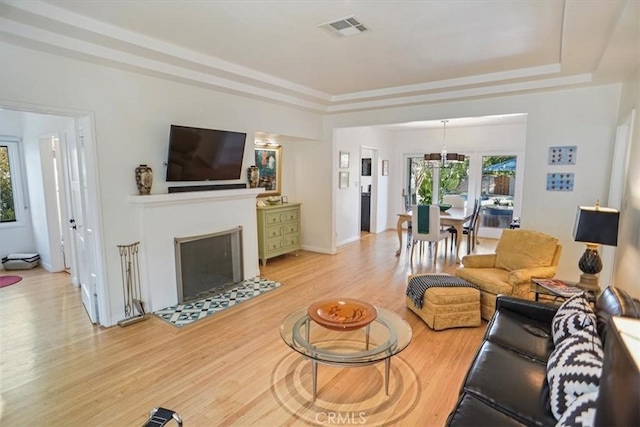 living room featuring light hardwood / wood-style floors and a raised ceiling