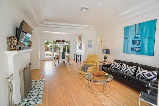 living room with hardwood / wood-style floors and a tray ceiling