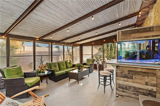 sunroom / solarium featuring vaulted ceiling with beams