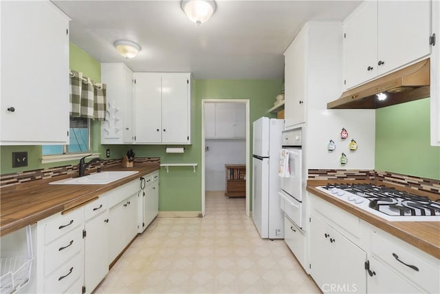 kitchen featuring sink, white cabinets, tasteful backsplash, and white appliances