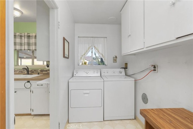 laundry area featuring washer and dryer, sink, and cabinets