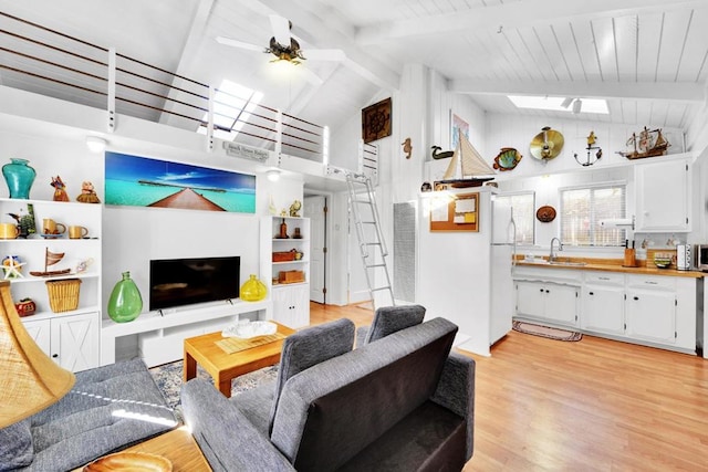 living room featuring light hardwood / wood-style floors, ceiling fan, wooden ceiling, beamed ceiling, and sink