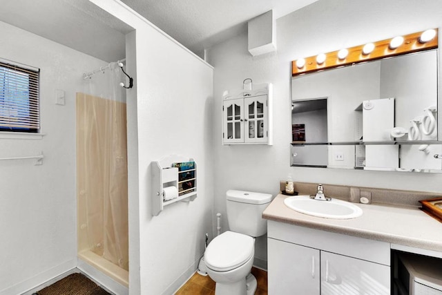 bathroom with vanity, curtained shower, and toilet