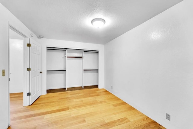 unfurnished bedroom with hardwood / wood-style flooring and a textured ceiling