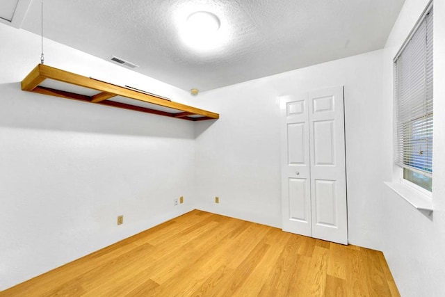 unfurnished bedroom with hardwood / wood-style floors and a textured ceiling